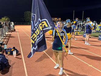 cheerleader at football game with flag
